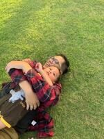 asiático padre y hijo teniendo divertido al aire libre en el prado. foto