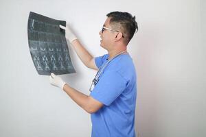 Doctor examining MRI images of patient with multiple sclerosis in clinic, space for text photo