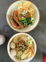 mushroom chicken noodles complete with vegetables and wonton crackers topped with stir-fried chicken and mushrooms in a white bowl Noodle chicken mushroom photo