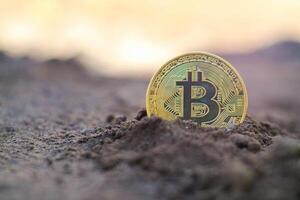 Bitcoin Golden on ground soil deep with light Virtual cryptocurrency bitcoin mining concept. photo