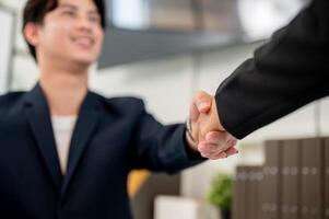 A close-up of a businessman shaking hands with his colleague or business partner. photo
