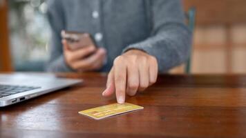 A close-up of a woman pointing at a credit card on a table, shopping online, online payment. photo