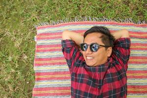 parte superior ver de contento asiático hombres gasto hora en día festivo. picnic en naturaleza en un verano día. ocio, verano, relajarse foto