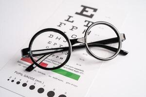 Glasses on eye testing exam chart to check eyesight accuracy photo