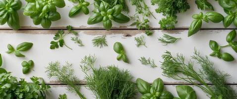 Aerial view of fresh green garden herbs like basil dill and parsley arranged on a rustic wooden table with ample space for text at the bottom photo