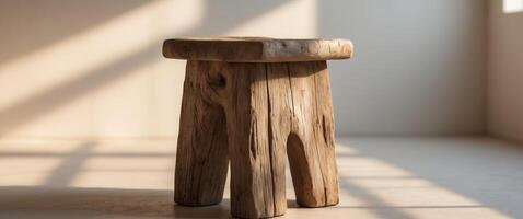 Rustic wooden stool in natural light with textured shadows indoors. photo