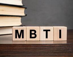 MBTI Letters on Wooden Blocks Surrounded by Books on Desk photo