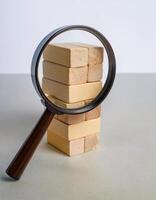 Side View of Magnifying Glass and Wooden Blocks for Data Analysis photo