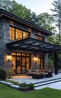 Stone house with outdoor seating. A beautiful stone house features a cozy outdoor seating area illuminated by soft lights in the evening. photo