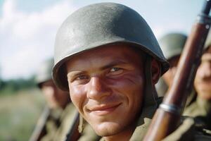 Smiling soldier in uniform with rifle poses for the camera in a military setting during the daytime photo