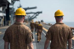 Military personnel in uniform walk on the deck of a naval vessel under a clear sky during a training exercise photo