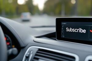 Display showing subscribe option in a modern car while driving on a tree-lined road during the day photo