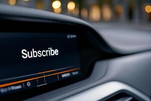 A close-up view of a dashboard in a modern vehicle highlights the prominent subscribe button in a sleek interface as evening lights softly illuminate the background photo
