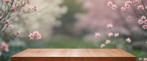 Wooden table top on blurred background of spring garden with pink flowers. photo