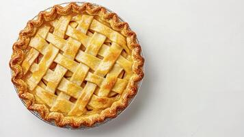 Freshly baked lattice-top apple pie on a smooth white surface showcasing its golden crust and inviting filling photo