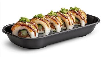 Deliciously arranged sushi rolls garnished with green onions served on a black platter with savory drizzle photo