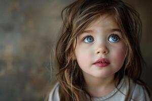 Portrait of cute little girl with big blue eyes looking up with hope photo