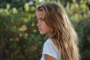 Blonde teenager girl posing with long hair in nature photo