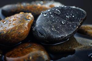 Wet pebbles reflecting on dark surface with water drops creating relaxing zen atmosphere photo