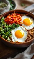 A bowl of food with broccoli, carrots, and eggs photo