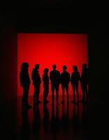 A group of people standing in front of a red light photo