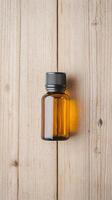 A brown glass bottle on a wooden surface, ideal for essential oils or liquids. photo