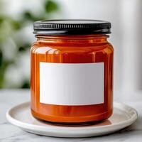 Bright orange candle in a jar ready for customization or to add warmth to any space. photo