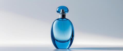 Elegant blue glass perfume bottle stands out with its unique shape and smooth design on a clean background. photo