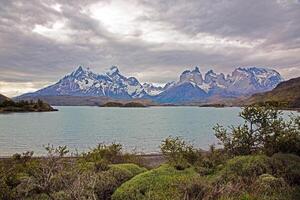 Panoramic view of Lake Pehoe with reflections of dramatic mountains and expansive skies in Torres del Paine i photo