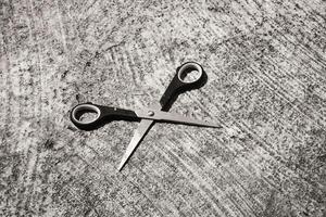 Mini scissors on cement floor. Monochrome of paper cutting tools. Unique office equipment. Negative space. Wallpaper. Backgrounds. Isolated Objects Photography concepts photo