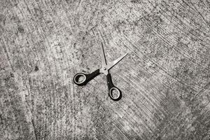 Black and white mini scissors on cement floor. Monochrome of paper cutting tools. Unique office equipment. Negative space. Wallpaper. Backgrounds. Isolated Objects Photography photo