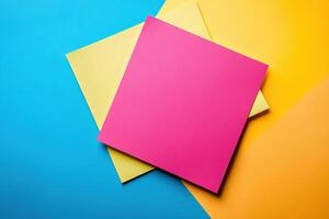 Square sheets of yellow and pink note paper lie on a blue surface. Generated by artificial intelligence photo