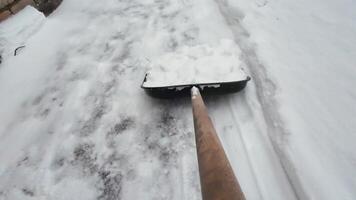 A shovel is being used to clear the snow from the sidewalk video