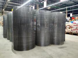 Sale of welded galvanized mesh in rolls in a building materials store inside, background photo