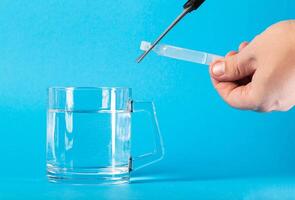 A man uses scissors to cut off a tube of laxative medicine for the intestines. Laxative for constipation. Copy space for text, ulcerative photo