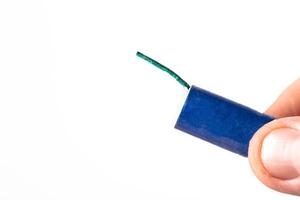 Firecracker with a wick in hand on a white background, isolate, close-up. Copy space for text. Fireworks Explosion Safety photo