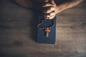 prayer man and wooden cross on the Bible photo