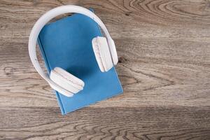 A pair of headphones on a book on a wooden table photo