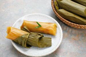 Lemet Singkong or Utri or Ketimus, Indonesian traditional cake that uses processed grated cassava inside which is given brown sugar wrapped in banana leaves and steamed. photo
