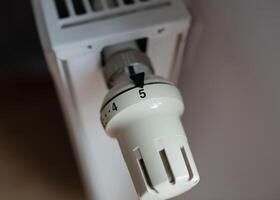Close-up of a thermostatic temperature control valve on a radiator. Concept of energy efficiency, temperature regulation, and home heating. photo
