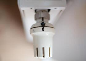 Close-up of a thermostatic temperature control valve on a radiator. Concept of energy efficiency, temperature regulation, and home heating. photo
