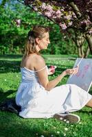 View of thr female artist paints a picture with pink paints photo