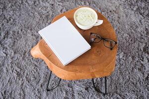 blank book mockup on white coffee table with green matcha tea photo