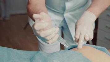 An orthopedist-traumatologist makes an injection with a large needle. Injection with a large syringe with a large needle video