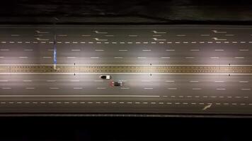 Top-down view of multi-lane highway at night. A brightly lit, top-down view of a multi-lane highway at night, video