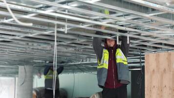Interior builder that makes the installation of suspended ceilings. Creating a framework for the ceiling. video