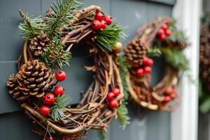 Christmas wreaths with pine cones and red berries hanging on a gray door photo