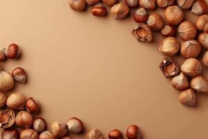 Hazelnuts bordering solid beige background creating negative space photo