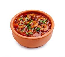 Delicious shrimp dish in a clay pot garnished with fresh herbs and spices photo