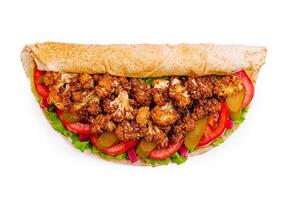 Delicious wrap filled with crispy cauliflower, fresh vegetables, and savory sauce in a whole grain tortilla photo